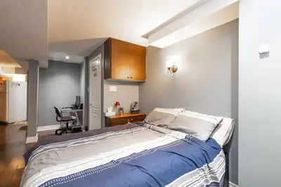 a bedroom with a large bed and a desk at Affordable Private Suite, Near Airport, Free Parking in Mississauga