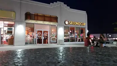 a person sitting in front of a store at night at Affordable Private Suite, Near Airport, Free Parking in Mississauga
