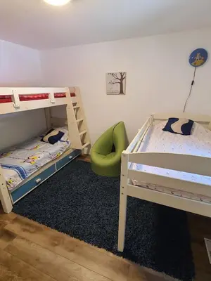 a bedroom with two bunk beds and a green chair at The Hidden Pearl in Haliburton