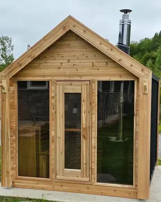 a wooden shed with a large window at The Hidden Pearl in Haliburton