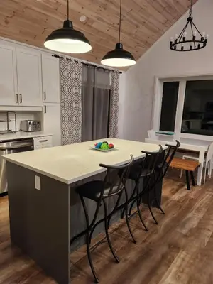 a kitchen with a large island with chairs around it at The Hidden Pearl in Haliburton