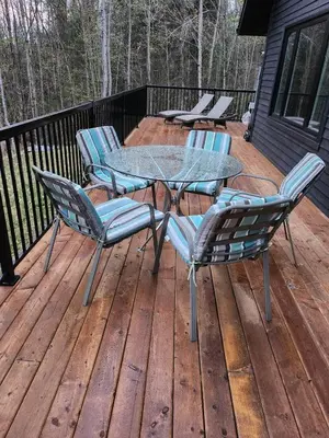 a patio with a table and chairs on a deck at The Hidden Pearl in Haliburton