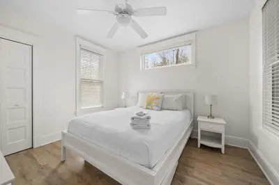 a white bedroom with a bed and a ceiling fan at L'Hibou - 18 Farm View in Cherry Valley