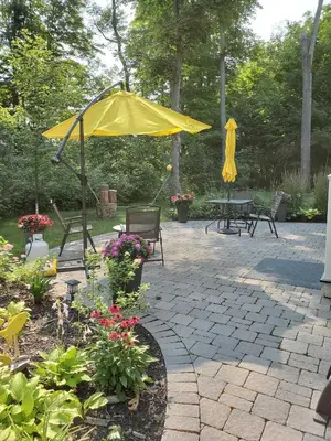 a patio with a yellow umbrella and tables and chairs at L'Hibou - 18 Farm View in Cherry Valley