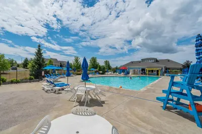 a swimming pool with chairs and blue chairs at L'Hibou - 18 Farm View in Cherry Valley