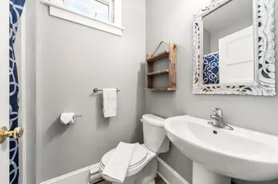 a bathroom with a sink and a toilet and a mirror at The Elm - 36 Hollow in Cherry Valley