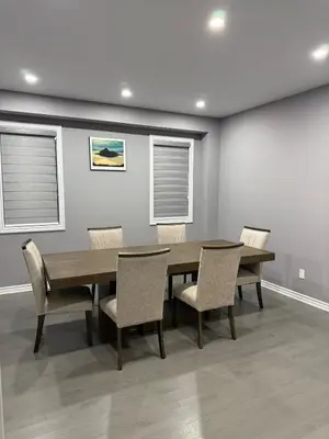 a dining room with a wooden table and chairs at 4-Bdrm Comfort with Fireplace mins from Downtown in Port Colborne