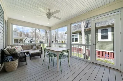 a screened porch with a table and a couch at The Hemlock - 1 Hollow in Cherry Valley