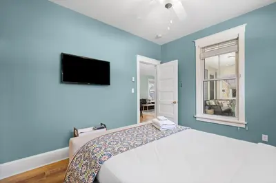 a blue bedroom with a bed and a flat screen tv at The Hemlock - 1 Hollow in Cherry Valley
