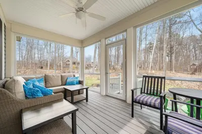 a screened porch with a couch and a table at The Cedar - 6 Hollow in Cherry Valley