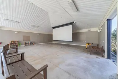a large room with a white screen in the middle at The Cedar - 6 Hollow in Cherry Valley