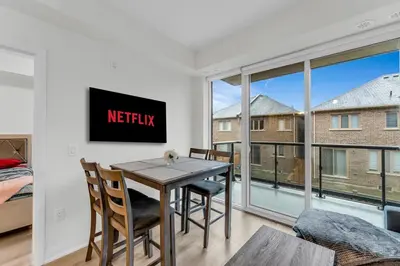 a dining room with a table and chairs and a large window at Luxury Spacious Apartment 10 min to Airport Wifi in Brampton
