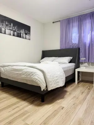 a bedroom with a bed and purple curtains at 1 Bedroom Apartment with Living Room and Full Washroom to yourself alone and a private car park in London