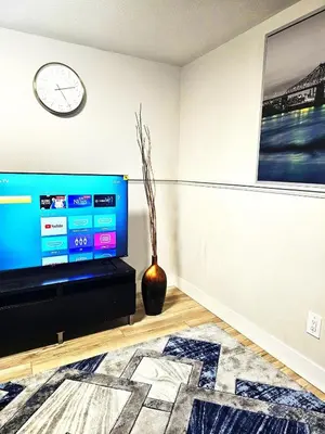 a living room with a tv and a clock on the wall at 1 Bedroom Apartment with Living Room and Full Washroom to yourself alone and a private car park in London