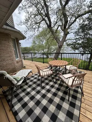 a patio with a table and chairs on a deck at Comfy Waterfront Suite 2 Double Beds Ensuite in Belleville