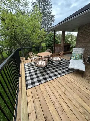 a wooden deck with a table and chairs on it at Comfy Waterfront Suite 2 Double Beds Ensuite in Belleville
