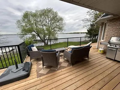 a deck with chairs and a table and a stove at Comfy Waterfront Suite 2 Double Beds Ensuite in Belleville
