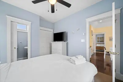 a bedroom with a white bed with a ceiling fan at 93 Butternut in Cherry Valley
