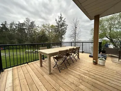 a wooden deck with a table and chairs on it at Guest Suite w Ensuite Waterfront in Belleville