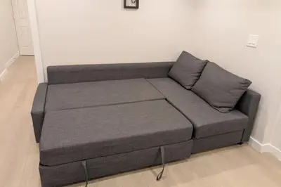 a gray couch in a living room at Elegant & Stylish Apartments with Private Entrance & Parking in Richmond Hill