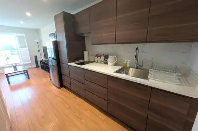 a kitchen with brown cabinets and a wooden floor at Elegant & Stylish Apartments with Private Entrance & Parking in Richmond Hill