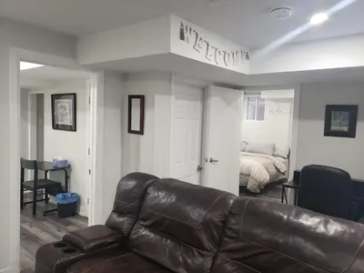 a living room with a leather couch and a bed at Velohome - 3-Bed, 2-Bath Home in Milton