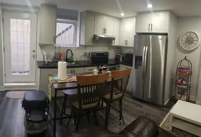 a kitchen with a table and a stainless steel refrigerator at Velohome - 3-Bed, 2-Bath Home in Milton