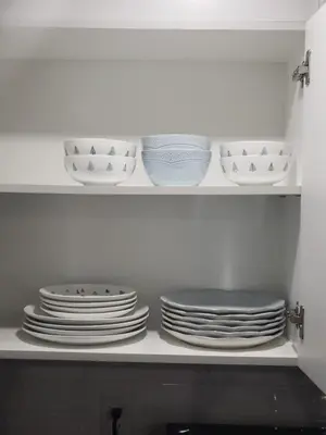a stack of plates and bowls on a shelf in a kitchen at Velohome - 3-Bed, 2-Bath Home in Milton