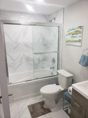 a white bathroom with a shower and a toilet at Velohome - 3-Bed, 2-Bath Home in Milton