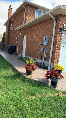 a house with two pots of flowers in front of it at B1 Beautiful and cozy private suite in Mississauga