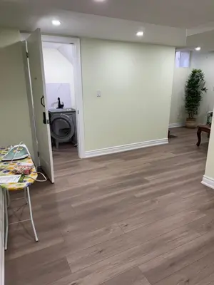 an empty room with a large white wall and wooden floors at B1 Beautiful and cozy private suite in Mississauga