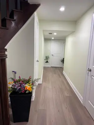 a hallway with a staircase with flowers in a vase at B1 Beautiful and cozy private suite in Mississauga