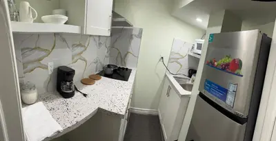 a small kitchen with a refrigerator and a counter at B01 cozy private room with bathroom in Mississauga