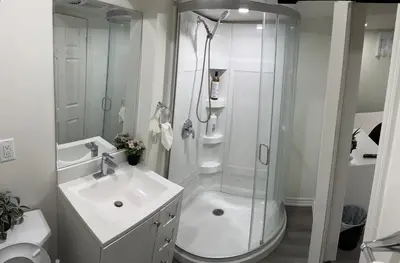 a white bathroom with a shower and a sink at B02 luxurious suite in Mississauga