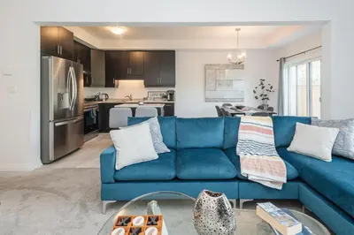 a living room with a blue couch and a kitchen at Luxury Living 5 mins from the Falls in Niagara Falls
