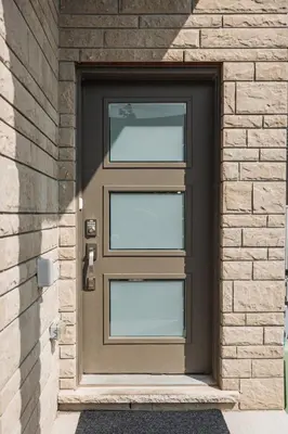 a brown door on a brick building at Luxury Living 5 mins from the Falls in Niagara Falls