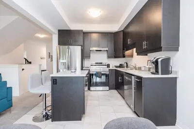 a kitchen with stainless steel appliances and black cabinets at Luxury Living 5 mins from the Falls in Niagara Falls