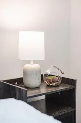 a bedside table with a lamp and a bowl of fruit at Luxury Living 5 mins from the Falls in Niagara Falls