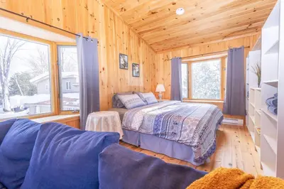 a bedroom with a bed in a wooden cabin at Lake View Loft in Severn