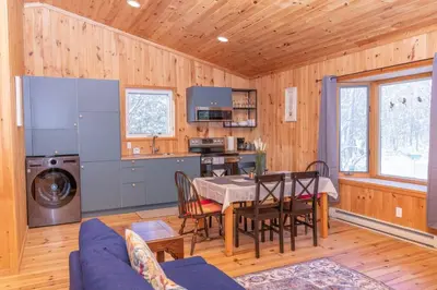 a kitchen and dining room with a table in a cabin at Lake View Loft in Severn