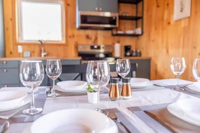 a table with wine glasses and plates on it at Lake View Loft in Severn