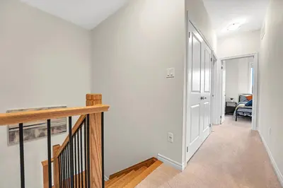 a hallway with white walls and a staircase in a house at Modern 5 Bed Home Near Burlington Pier, Downtown, Hospital, GO in Burlington