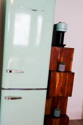 a white refrigerator freezer sitting next to a wooden shelf at Large Waterfront Home w 5 Ensuite Bathrooms in Belleville
