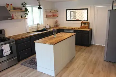 a kitchen with black cabinets and a white island at Large Waterfront Home w 5 Ensuite Bathrooms in Belleville