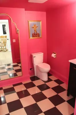 a pink bathroom with a toilet and a checkered floor at Large Waterfront Home w 5 Ensuite Bathrooms in Belleville