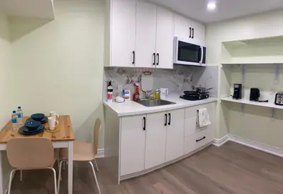 a small kitchen with white cabinets and a table at B3 Luxury home in Mississauga nearby shipping center square one in Mississauga