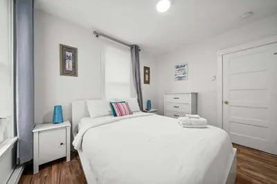 a white bedroom with a large bed and a window at The Tree Frog - 12 Pine Forest in Cherry Valley