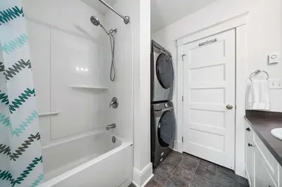 a bathroom with a washing machine next to a white door at The Tree Frog - 12 Pine Forest in Cherry Valley