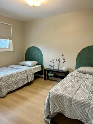 a bedroom with two beds and a table with flowers at Cheerful 4 bedroom with sunroom in Belleville