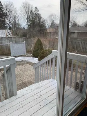 an open door to a deck with snow on the ground at Cheerful 4 bedroom with sunroom in Belleville
